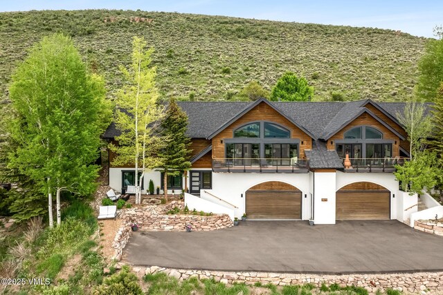 5780 Wildridge Rd E Unit A, Avon, CO 81620 - view of front of home with a balcony, stucco siding, driveway, and an attached garage