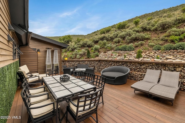 5780 Wildridge Rd E Unit A, Avon, CO 81620 - wooden deck with outdoor dining space, a mountain view, and an outdoor living space