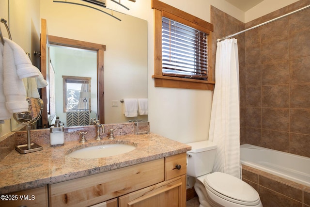 bathroom with tiled shower / bath, toilet, and vanity