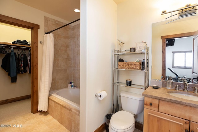 bathroom featuring toilet, tiled shower / bath combo, vanity, baseboards, and a walk in closet