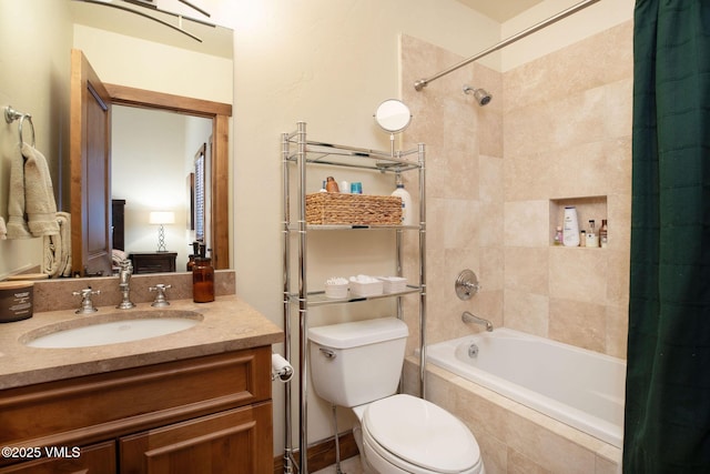 full bathroom featuring tiled shower / bath combo, toilet, and vanity