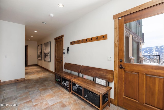 hallway featuring recessed lighting, a mountain view, and baseboards