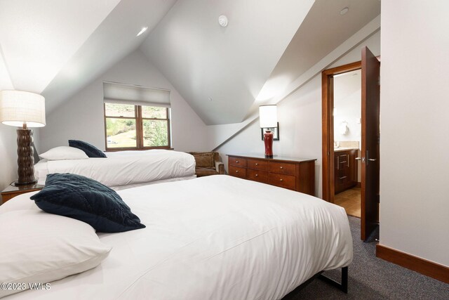 bedroom with lofted ceiling, connected bathroom, and carpet