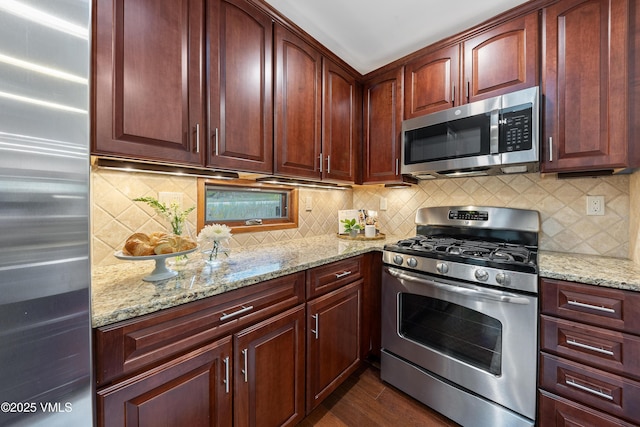 4254 Columbine Way Unit 9, Vail, CO 81657 - kitchen featuring appliances with stainless steel finishes, light stone countertops, backsplash, dark wood-style flooring, and reddish brown cabinets