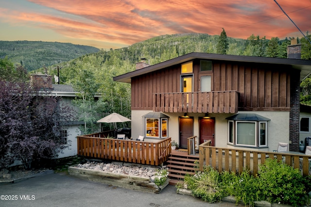 4254 Columbine Way Unit 9, Vail, CO 81657 - view of front of property with a chimney, a balcony, a mountain view, and stucco siding