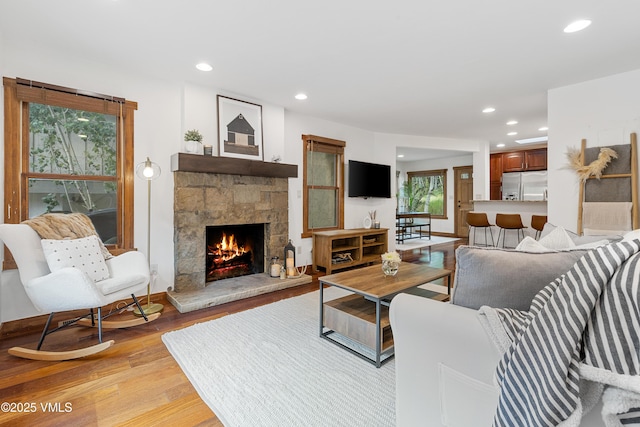 4254 Columbine Way Unit 9, Vail, CO 81657 - living area featuring light wood-type flooring, a stone fireplace, and recessed lighting