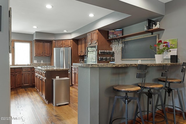 kitchen with stainless steel appliances, plenty of natural light, a peninsula, open shelves, and recessed lighting