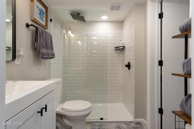 bathroom featuring a shower stall, toilet, and vanity
