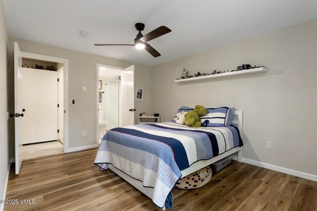 bedroom with wood finished floors, baseboards, connected bathroom, and a ceiling fan