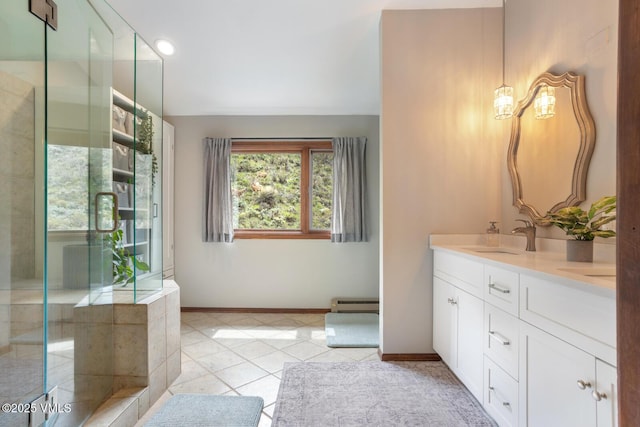 full bath featuring tile patterned floors, baseboards, double vanity, and baseboard heating