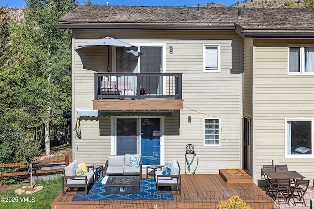 back of property featuring an outdoor hangout area, a balcony, a deck, and fence