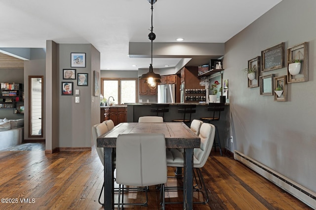 dining room with a baseboard heating unit, dark wood-style flooring, baseboards, and recessed lighting