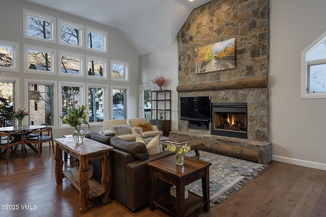 living area with high vaulted ceiling, a fireplace, dark wood finished floors, and baseboards