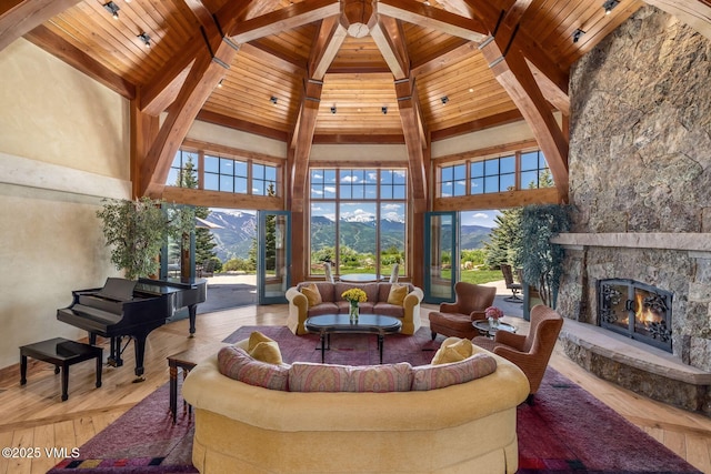 1006 Chiming Bells, Avon, CO 81620 - living room with a wooden ceiling with exposed beams, a mountain view, a stone fireplace, high vaulted ceiling, and wood finished floors