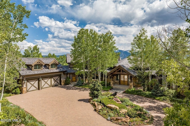 1006 Chiming Bells, Avon, CO 81620 - view of front facade featuring stone siding, decorative driveway, and a garage