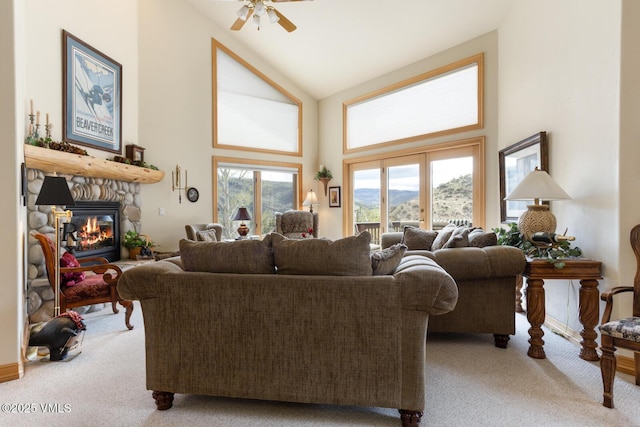 living area featuring carpet flooring, a mountain view, high vaulted ceiling, ceiling fan, and a fireplace