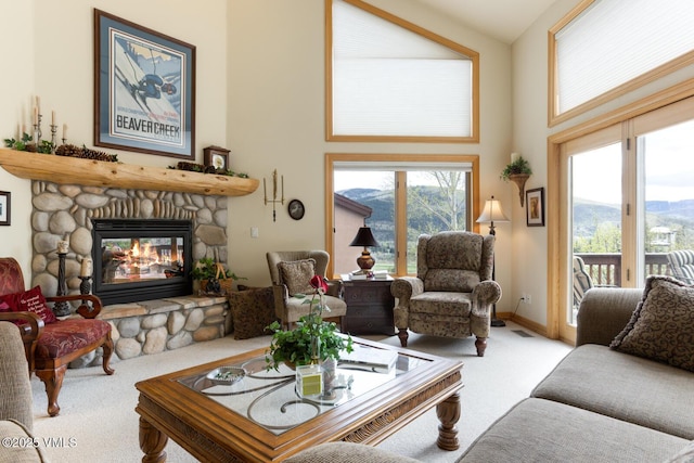 carpeted living area with a fireplace, a mountain view, and a towering ceiling