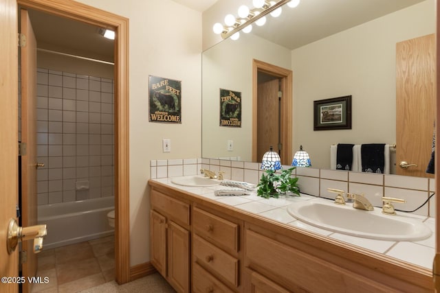 bathroom featuring double vanity, toilet, tile patterned flooring, and shower / bathtub combination