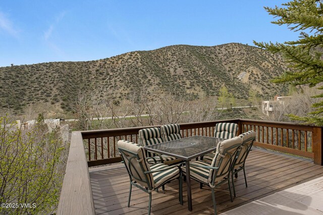 wooden deck featuring outdoor dining area and a mountain view