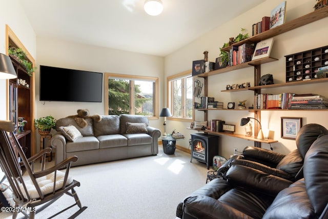 living area featuring carpet floors and a wood stove
