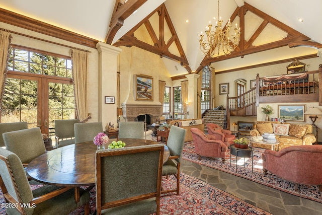 443 Beaver Dam Rd, Vail, CO 81657 - dining space with high vaulted ceiling, a fireplace, decorative columns, stairway, and a chandelier
