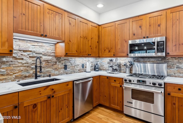 205 Bear Paw Unit B102, Avon, CO 81620 - kitchen featuring a sink, appliances with stainless steel finishes, decorative backsplash, and light wood-type flooring
