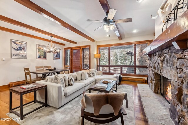 205 Bear Paw Unit B102, Avon, CO 81620 - living area featuring beamed ceiling, light wood finished floors, and ceiling fan with notable chandelier