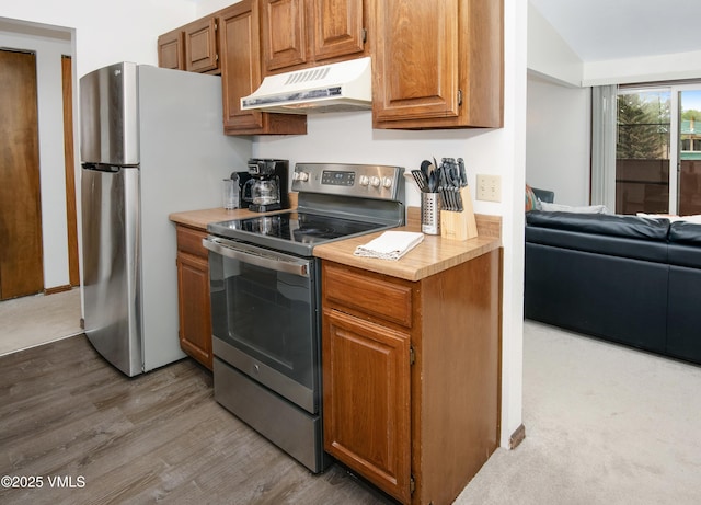 1061 W Beaver Creek Blvd Unit Q302, Avon, CO 81620 - kitchen featuring under cabinet range hood, electric range, light countertops, wood finished floors, and freestanding refrigerator