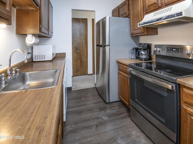 1061 W Beaver Creek Blvd Unit Q302, Avon, CO 81620 - kitchen featuring stainless steel appliances, under cabinet range hood, a sink, dark wood finished floors, and brown cabinetry
