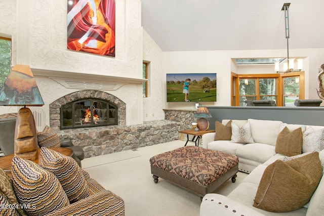 living room featuring carpet floors, vaulted ceiling, a stone fireplace, and a healthy amount of sunlight