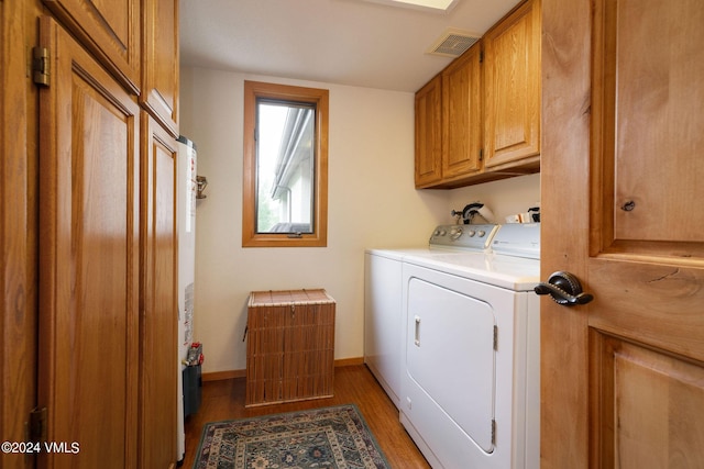 clothes washing area with cabinets, wood-type flooring, and separate washer and dryer