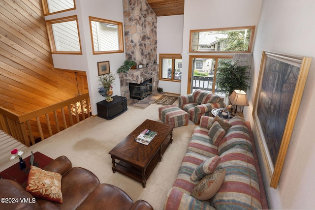 carpeted living room featuring a fireplace and a high ceiling