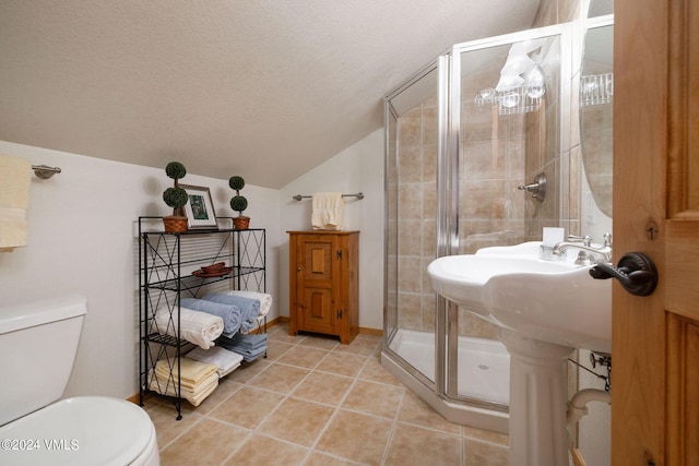 bathroom featuring a shower with door, a textured ceiling, vaulted ceiling, tile patterned floors, and toilet