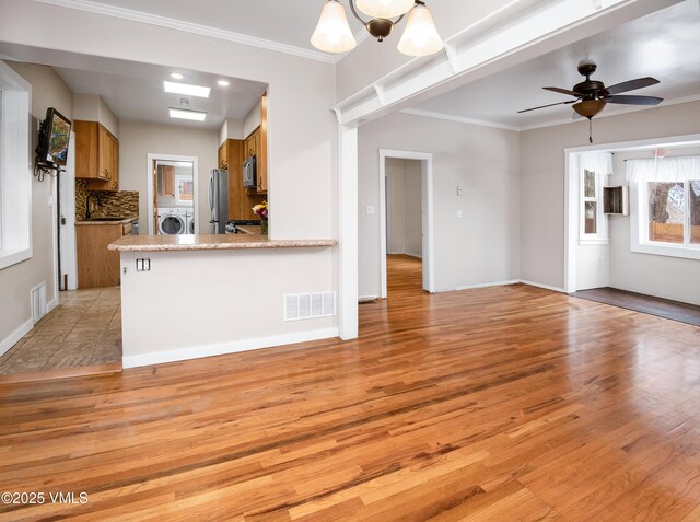 432 W Fifth St, Eagle, CO 81631 - kitchen featuring visible vents, brown cabinets, appliances with stainless steel finishes, crown molding, and light wood finished floors