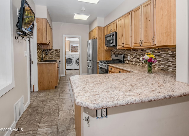 432 W Fifth St, Eagle, CO 81631 - kitchen featuring visible vents, a peninsula, washer and dryer, stainless steel appliances, and a sink
