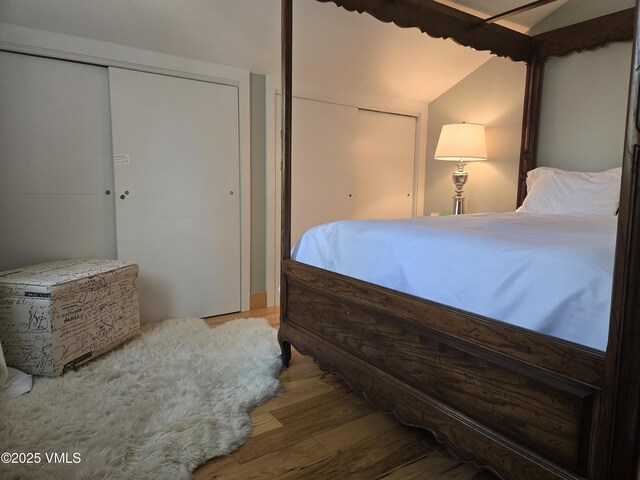 bedroom with hardwood / wood-style flooring and lofted ceiling