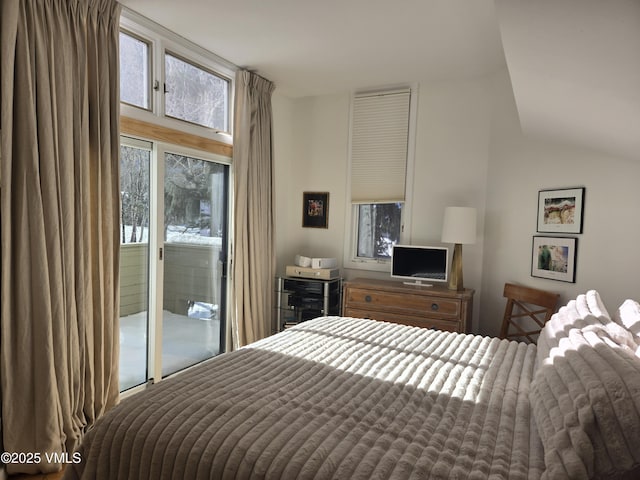 bedroom with lofted ceiling and access to outside