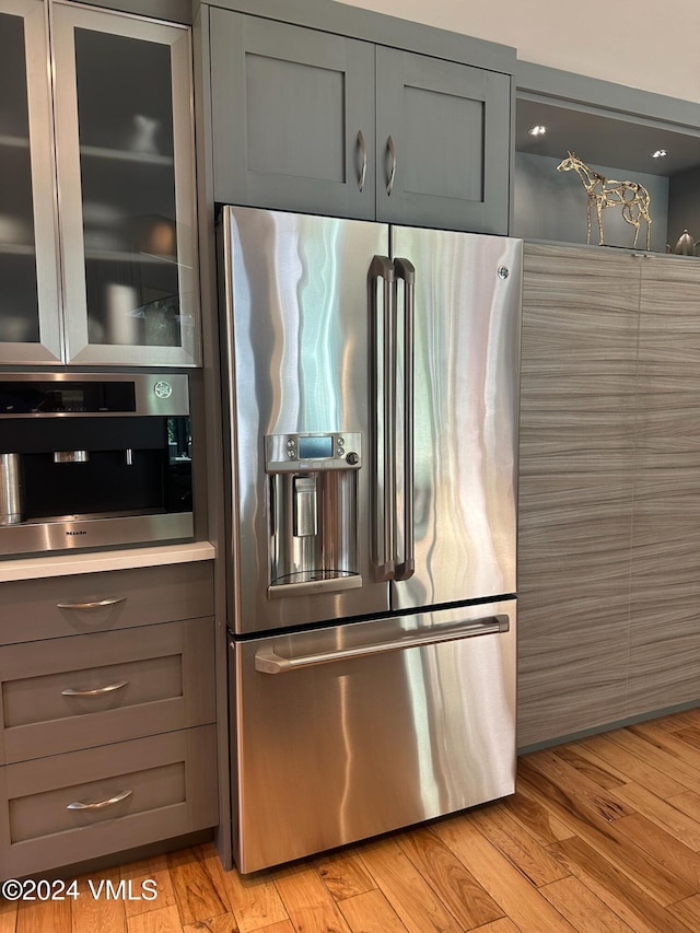 kitchen featuring stainless steel appliances, light hardwood / wood-style floors, and gray cabinetry