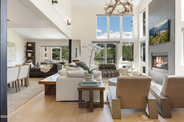 114 Mission Pl, Edwards, CO 81632 - living room featuring a towering ceiling, a chandelier, a fireplace, and light wood-type flooring