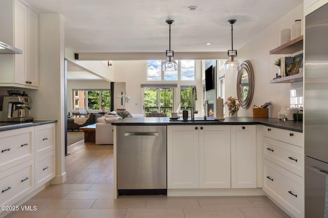 114 Mission Pl, Edwards, CO 81632 - kitchen featuring pendant lighting, sink, wall chimney range hood, white cabinetry, and stainless steel appliances