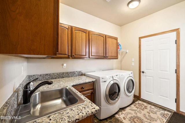 laundry area featuring separate washer and dryer, a sink, and cabinet space