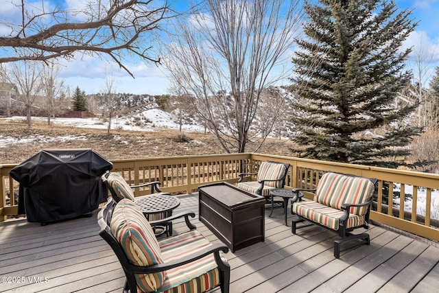 snow covered deck featuring grilling area and an outdoor hangout area