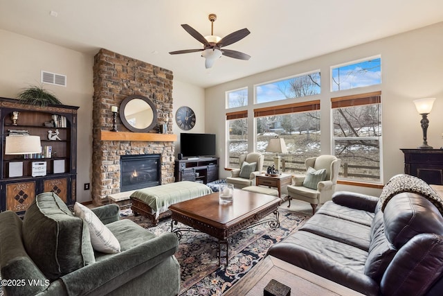 living room with ceiling fan, a fireplace, and visible vents