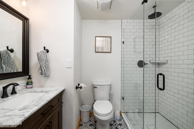 bathroom with vanity, toilet, and a shower with door