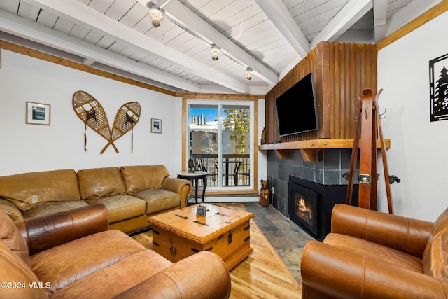 living room featuring wood ceiling, a baseboard heating unit, wood-type flooring, a tiled fireplace, and beamed ceiling