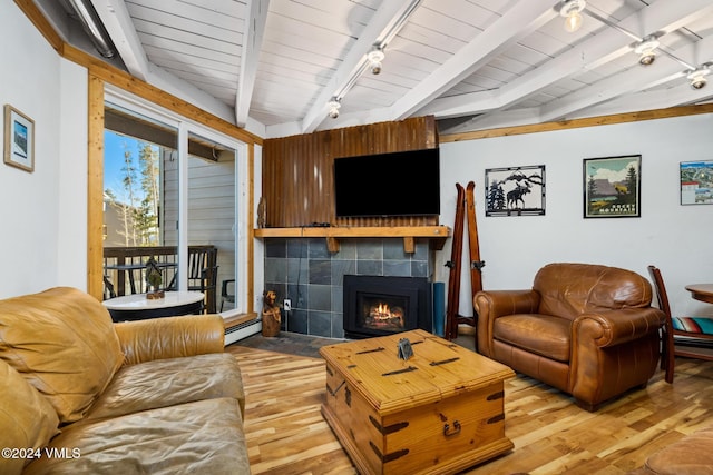 living room with hardwood / wood-style flooring, a baseboard heating unit, beam ceiling, track lighting, and a fireplace