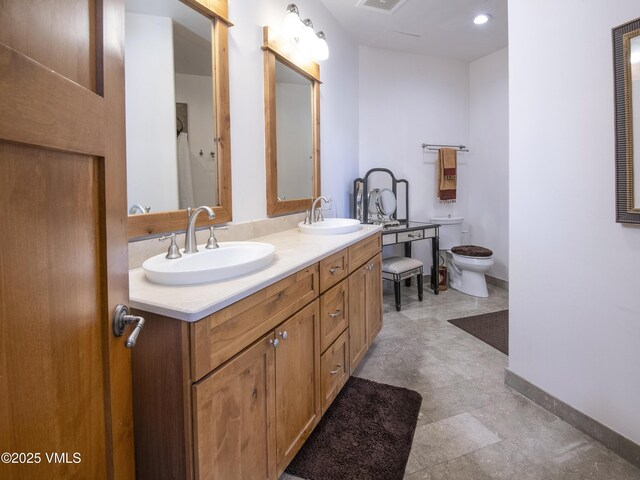 295 Main St Unit R-306, Edwards, CO 81632 - bathroom featuring double vanity, baseboards, and toilet