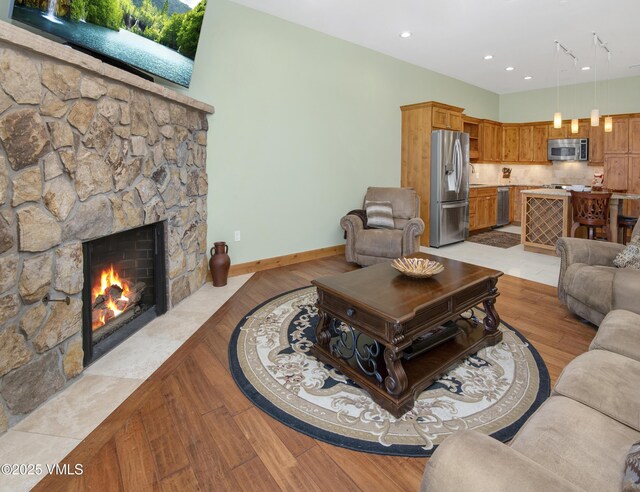 295 Main St Unit R-306, Edwards, CO 81632 - living room with a stone fireplace, light wood-style flooring, baseboards, and recessed lighting