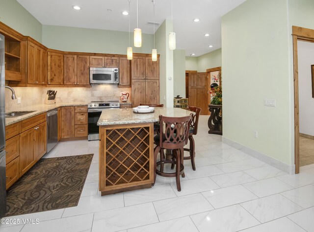 295 Main St Unit R-306, Edwards, CO 81632 - kitchen featuring stainless steel appliances, a sink, open shelves, tasteful backsplash, and a center island