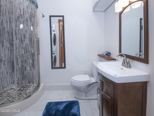 295 Main St Unit R-306, Edwards, CO 81632 - bathroom featuring stacked washer and clothes dryer, a shower stall, vanity, marble finish floors, and toilet